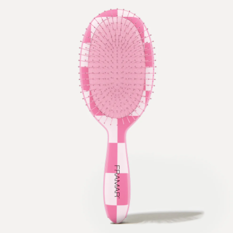 Pink hairbrush with white accents on a light gray background