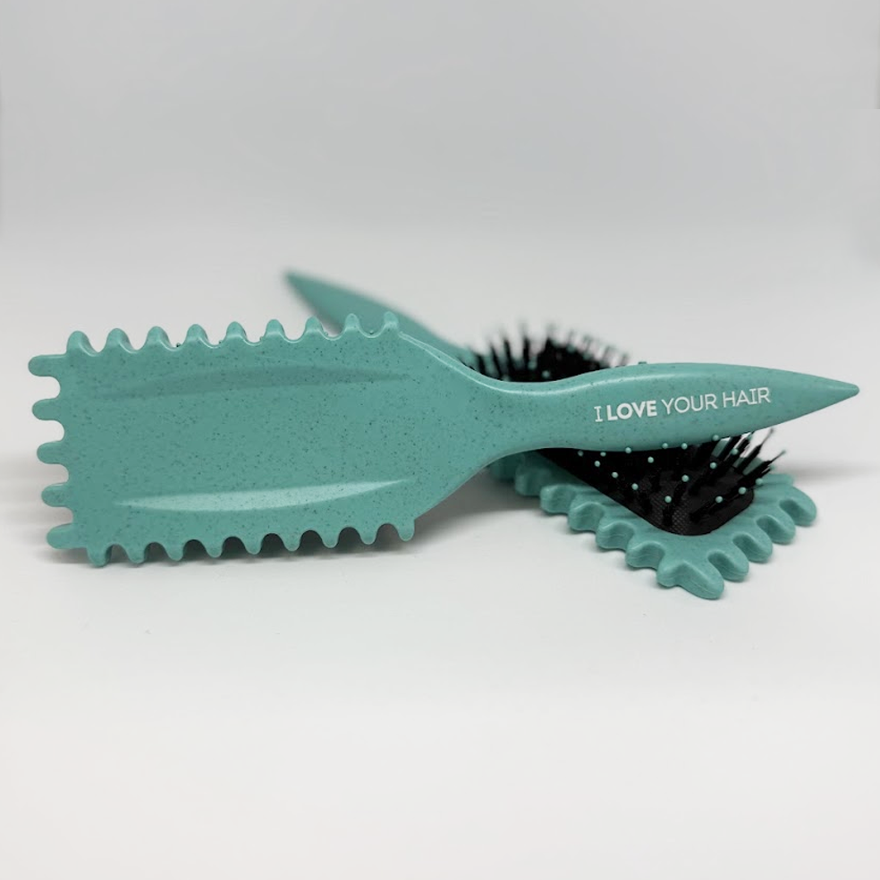 Teal hairbrush with textured head and 'I LOVE YOUR HAIR' text on a white background