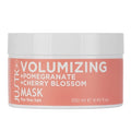 Volumizing mask jar with pomegranate and cherry blossom ingredients on a white background