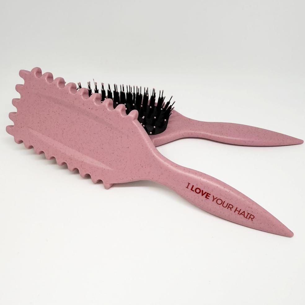 Pink hairbrush with black bristles on a white background