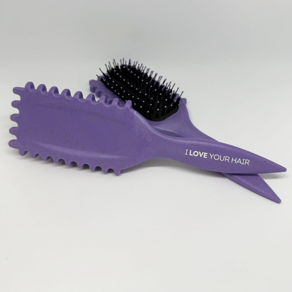 Purple hairbrush with black bristles on a white background